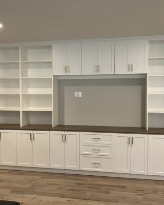 Built-in storage cabinetry with drawers and open shelving, highlighting the installation phase for garage or mudroom organization systems.