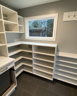 White reach-in closet system with drawers and shelving, symbolizing collaborative planning for custom closet and storage design solutions.