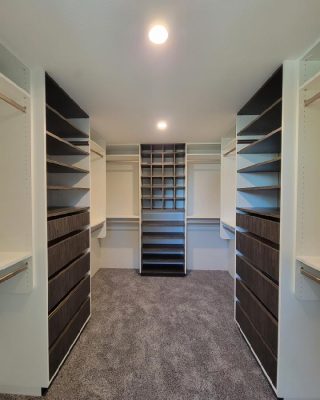 Modern walk-in closet with shelving and drawers, representing the first step in our custom closet consultation and planning process.